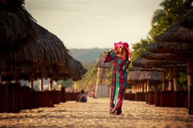 Sahilde büyük kırmızı şapkalı ince kız