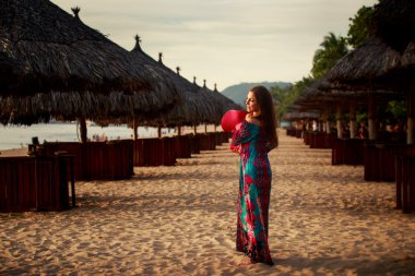 Sahilde büyük kırmızı şapkalı ince kız