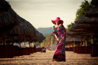 Sahilde büyük kırmızı şapkalı ince kız