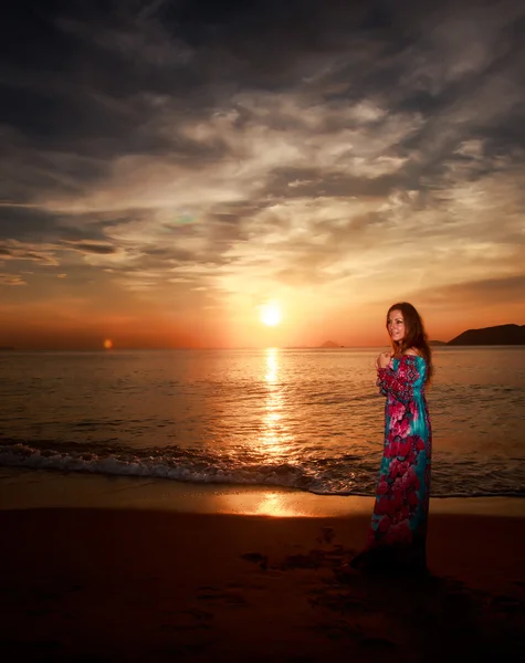 Smal tjej mot soluppgången över havet — Stockfoto