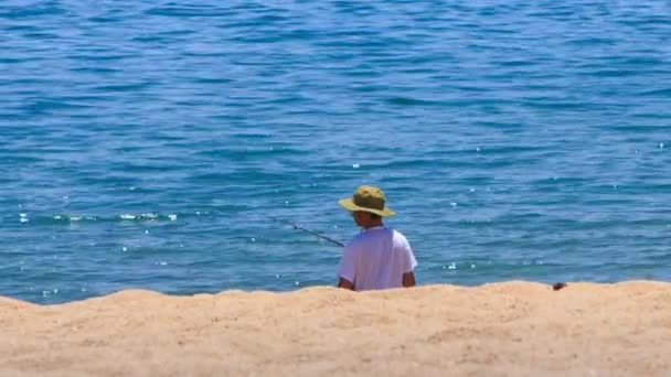 Pêcheur en chapeau poissons avec canne — Video