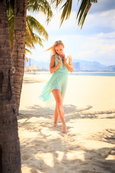 Blonde girl in azure looks  on beach — ストック写真