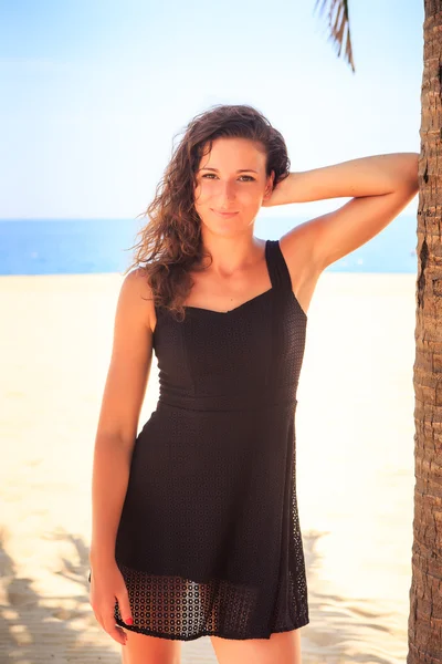 Girl in black lace frock on beach — Stok fotoğraf