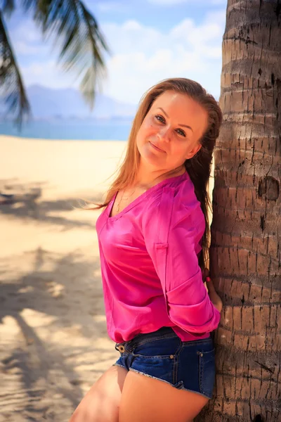 Mädchen in rosa gegen Sand und Meer — Stockfoto