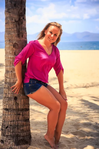 Girl in pink against sand and sea — Stock Photo, Image