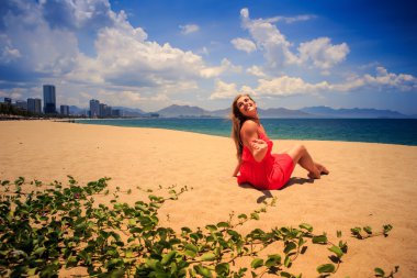 blond girl in red   on sand beach