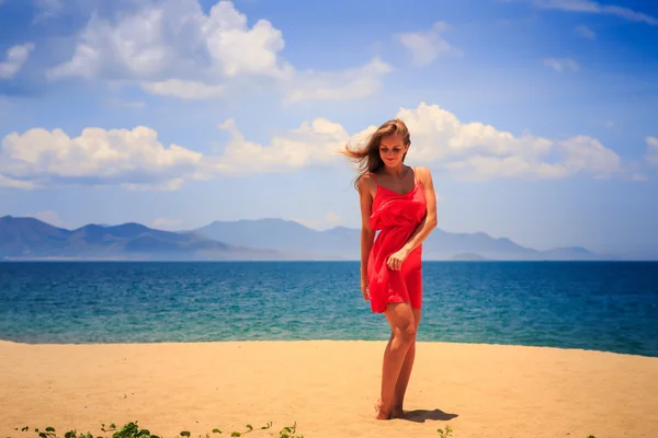 Menina loira em vermelho na praia de areia — Fotografia de Stock