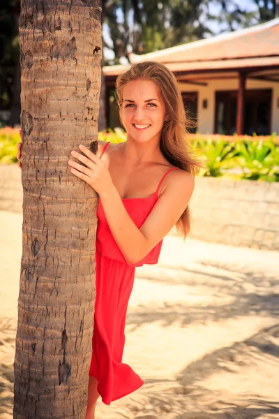 Blond girl against tropical plants — Stock Photo, Image