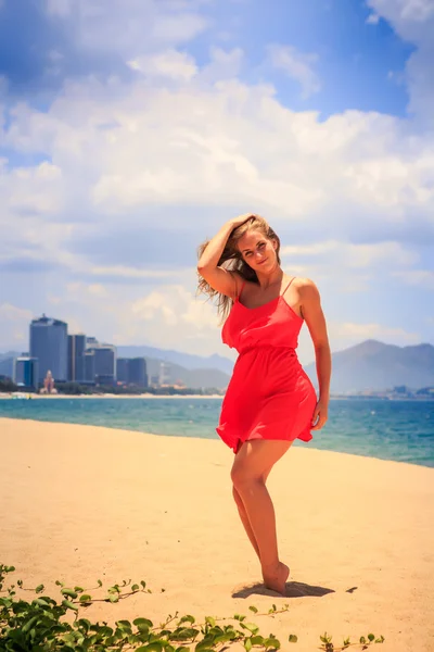 Menina loira em vermelho na praia de areia — Fotografia de Stock