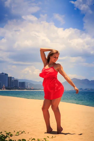 Blond girl in red   on sand beach — Stock Photo, Image