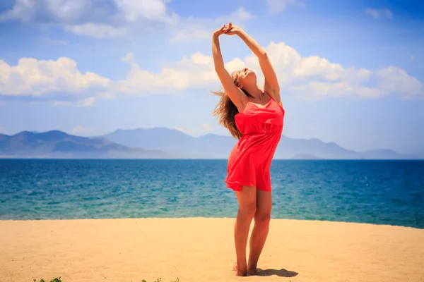 Blond girl in red   on sand beach Stock Picture