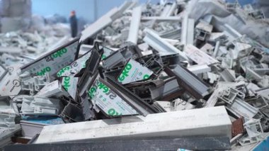 KYIV, UKRAINE - 15 Mart 2024: Çalışanlar atığı incelerken, pencere kenarlarındaki kırık plastik parçalar. Hasarlı yapı malzemelerinin birikmesi sanayi bölgesinde yığınlar oluşturur