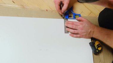 İnşaat işçisi doğru kesim olmadığından emin olmak için bordaya işaretler çiziyor. Mobilyacı kesime hazırlanmak için kabine beyaz tahtasının yüzeyine çizgiler çiziyor