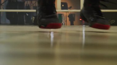 Sporcu ringde dövüşmeden önce bacak ve ayak kaslarını ısıtır. Profesyonel oyuncu atlıyor ve zeminin gelişmekte olan vücudunun pürüzsüz yüzeyini itiyor.