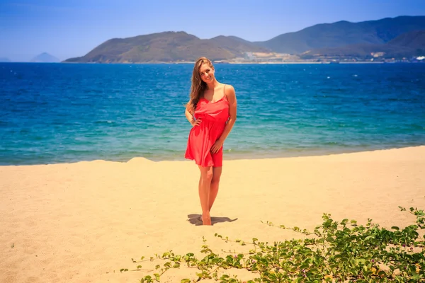 Blonde fille se tient pieds nus sur le sable — Photo