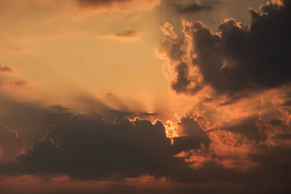 Stijgende zonnestralen achter de wolken — Stockfoto