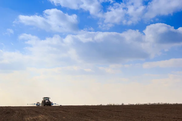 Clouds above dark ploughed field — Stock Photo, Image