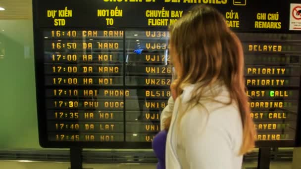 Blond girl looks at timetable — Stock Video