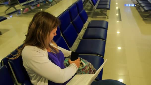 Girl puts iphone laptop into handbag — Stock Video