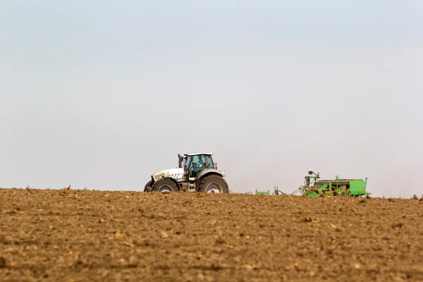 Трактор работает на горизонте — стоковое фото