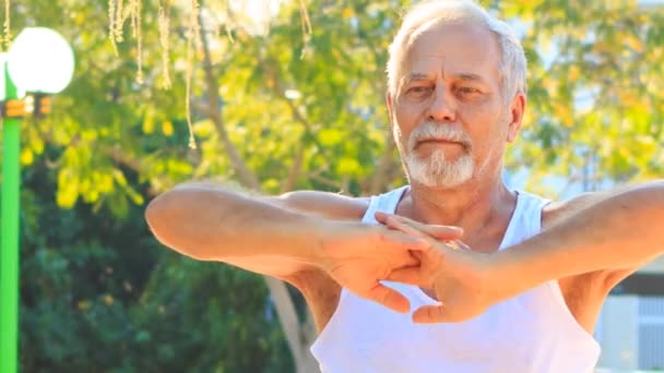 Viejo hombre estira las manos — Vídeo de stock