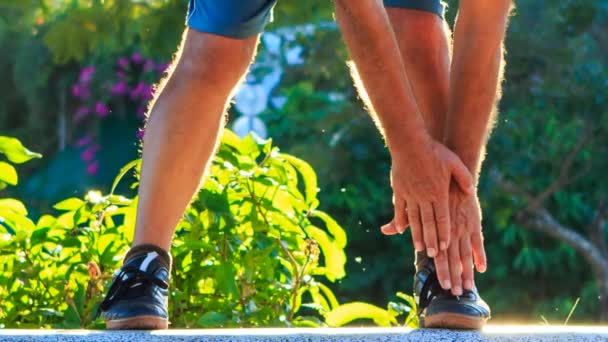 Man bends hands to feet — Stock Video