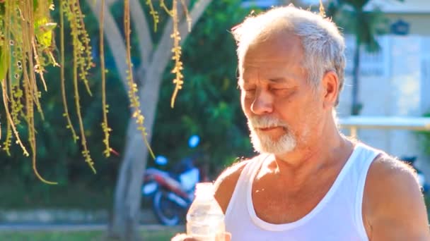 Yaşlı adam su içer — Stok video