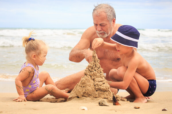 Grandpa  and children  Building Sand Castle