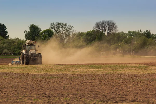 Действующий трактор в почве — стоковое фото