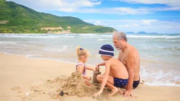 Abuelo con chico y chica en la playa — Vídeos de Stock