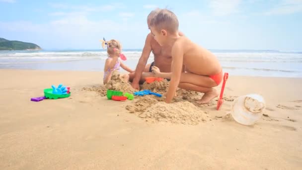 Дедушка с парнем и девочкой на пляже — стоковое видео