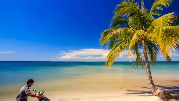 gars en scooter sur la plage tropicale 