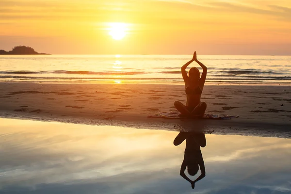 Silhouet van de vrouw zittend op strand — Stockfoto