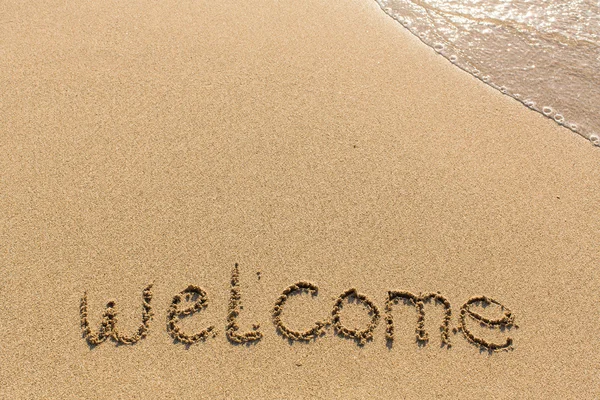 Bem-vindo - palavra desenhada na praia de areia — Fotografia de Stock