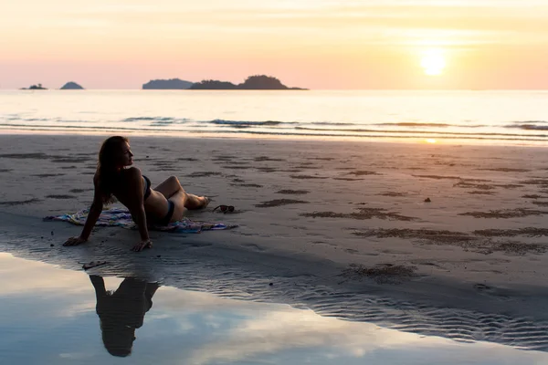 Mulher que coloca no pôr do sol praia do mar . — Fotografia de Stock