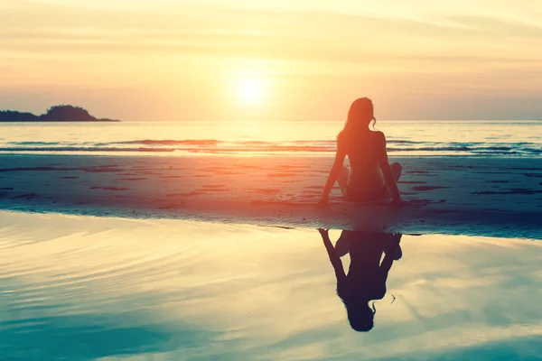 Frau sitzt am Strand — Stockfoto