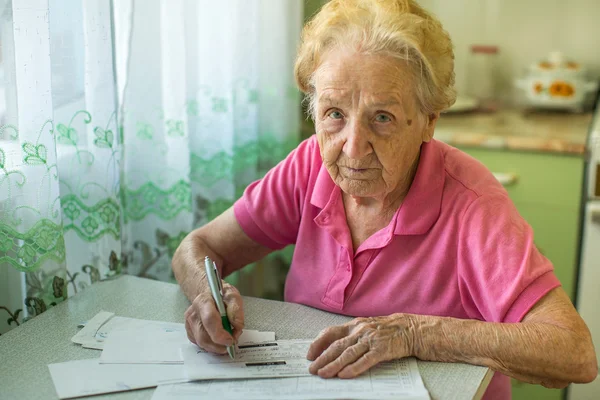 Žena sedí u stolu výplně — Stock fotografie