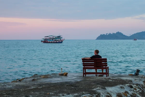 Un homme seul assis sur un banc — Photo