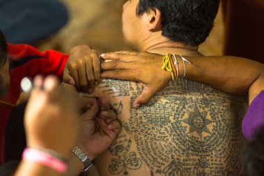 Monk makes traditional Yantra tattooing clipart