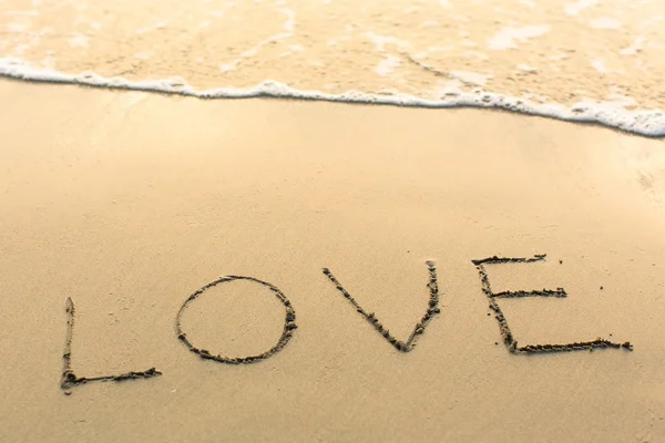 Love - written on texture of sea sand. — Stock Photo, Image