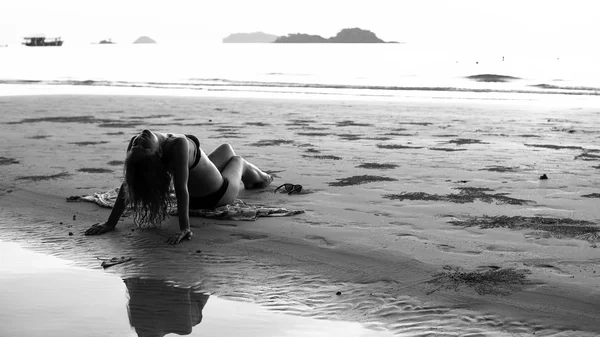 Giovane bella donna sdraiata sulla spiaggia. Fotografia in bianco e nero . — Foto Stock