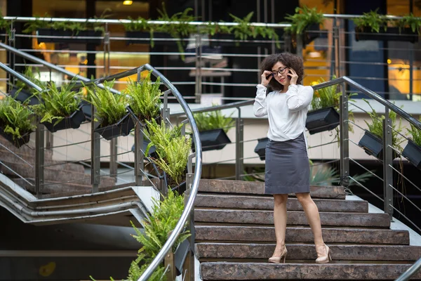 年轻的亚洲业务女人谈移动站在楼梯间. — 图库照片