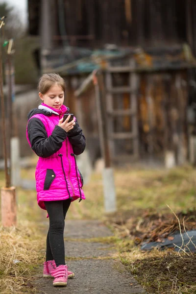 Petite fille mignonne tapant sur mobile, en plein air . — Photo