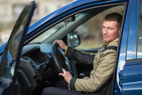 Jongeman zit in nieuwe auto — Stockfoto