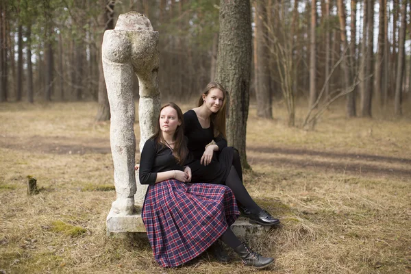 Teen girls sitting on broken sculpture — Stock Photo, Image