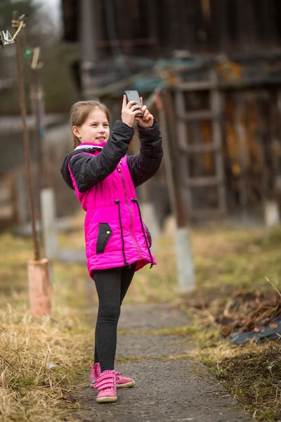 Маленькая девочка делает селфи на смартфоне — стоковое фото