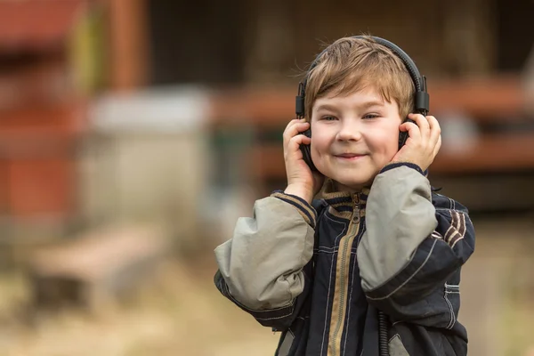 Kleine jongen luisteren naar muziek in hoofdtelefoon — Stockfoto