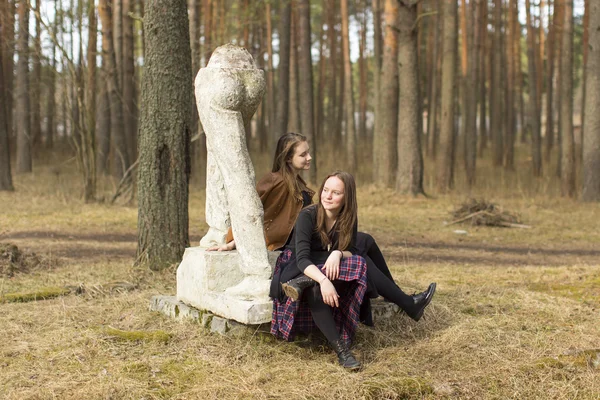 Meninas sentadas nas esculturas antigas — Fotografia de Stock