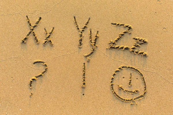 Alphabet written on sandy beach — Stock Photo, Image