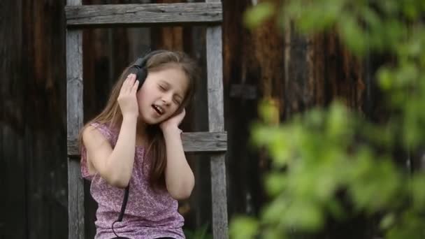 Schattig meisje geniet van muziek — Stockvideo